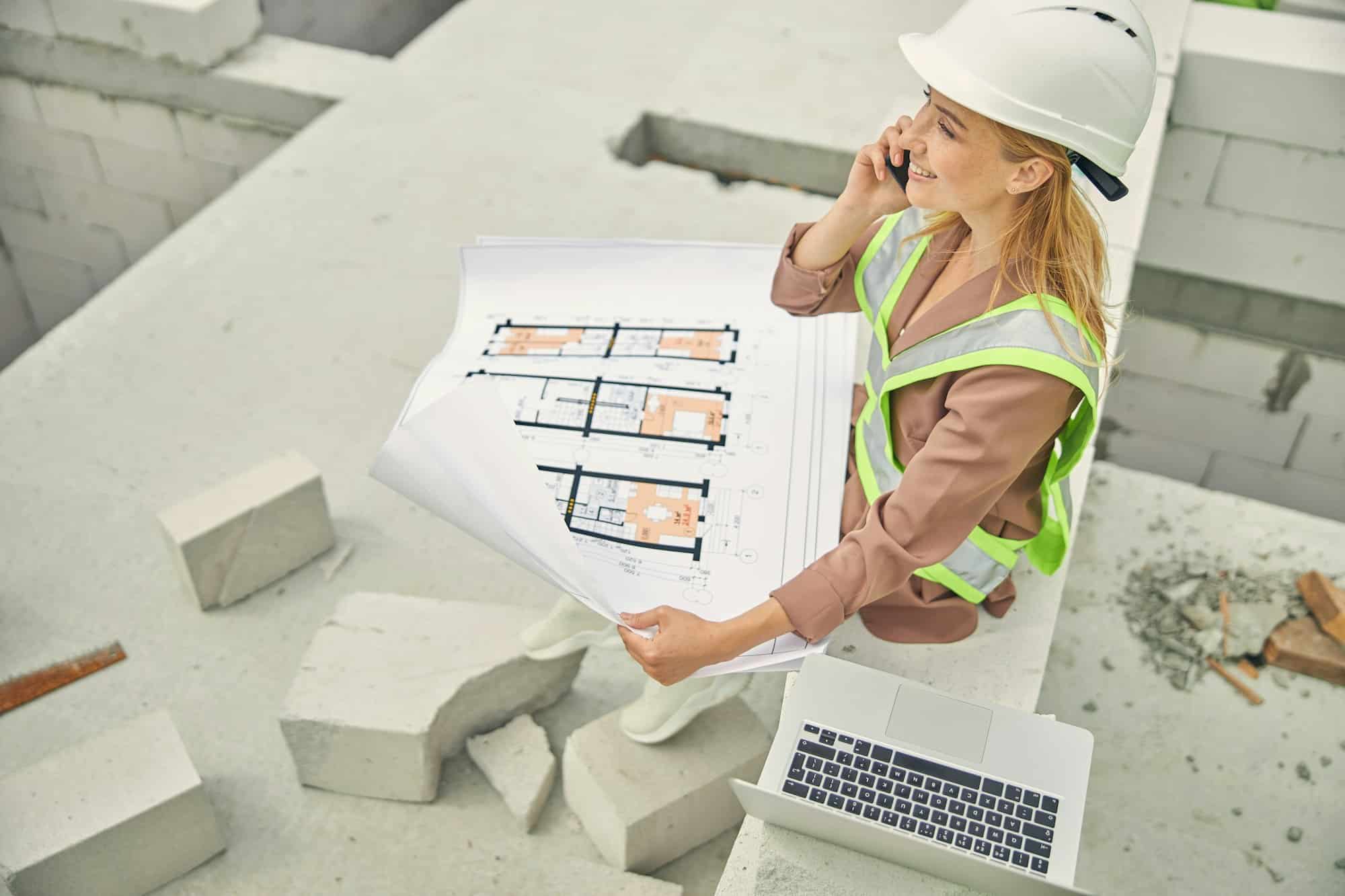 Pleased construction manager calling on her smartphone