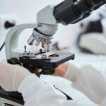 Lab technician examining cells under the microscope
