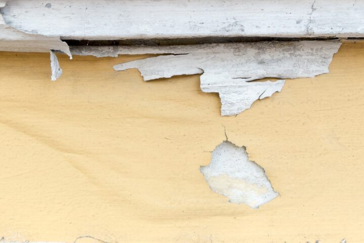 Yellow paint peeling off at concrete wall,texture background